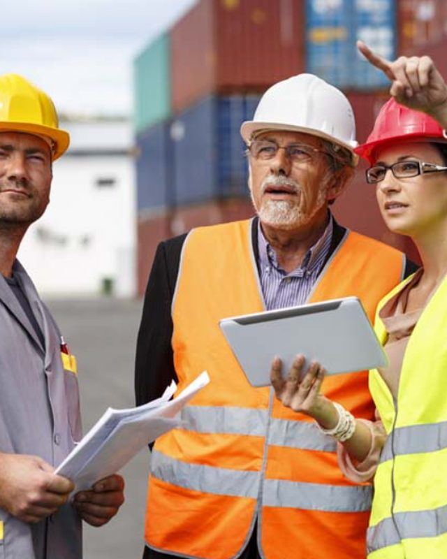 Industrial safety team reviewing site conditions in PPE